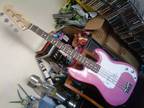 Pink electric bass guitar and accessories